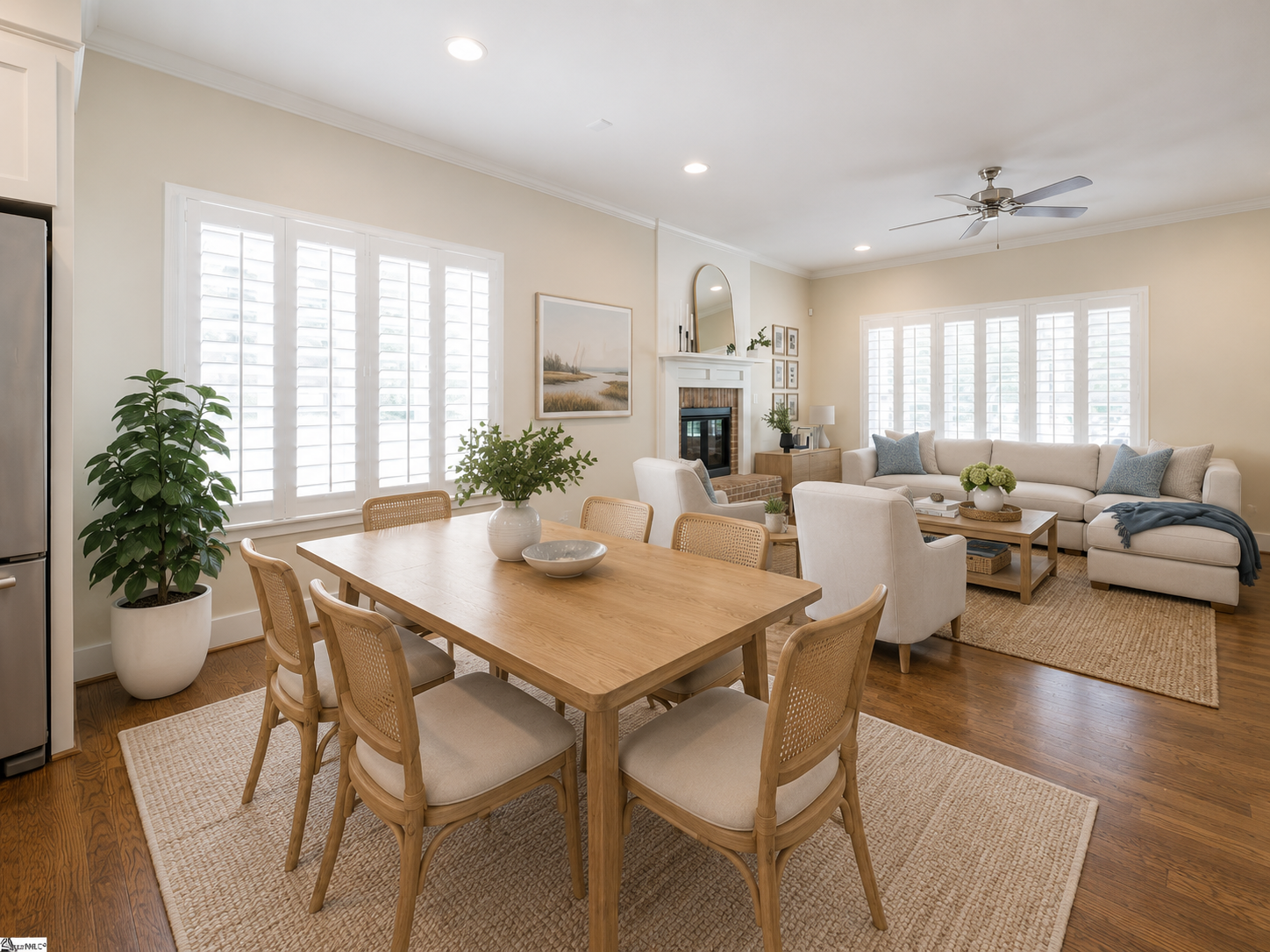 Dining area opening into the living room with plantation shutters and fireplace