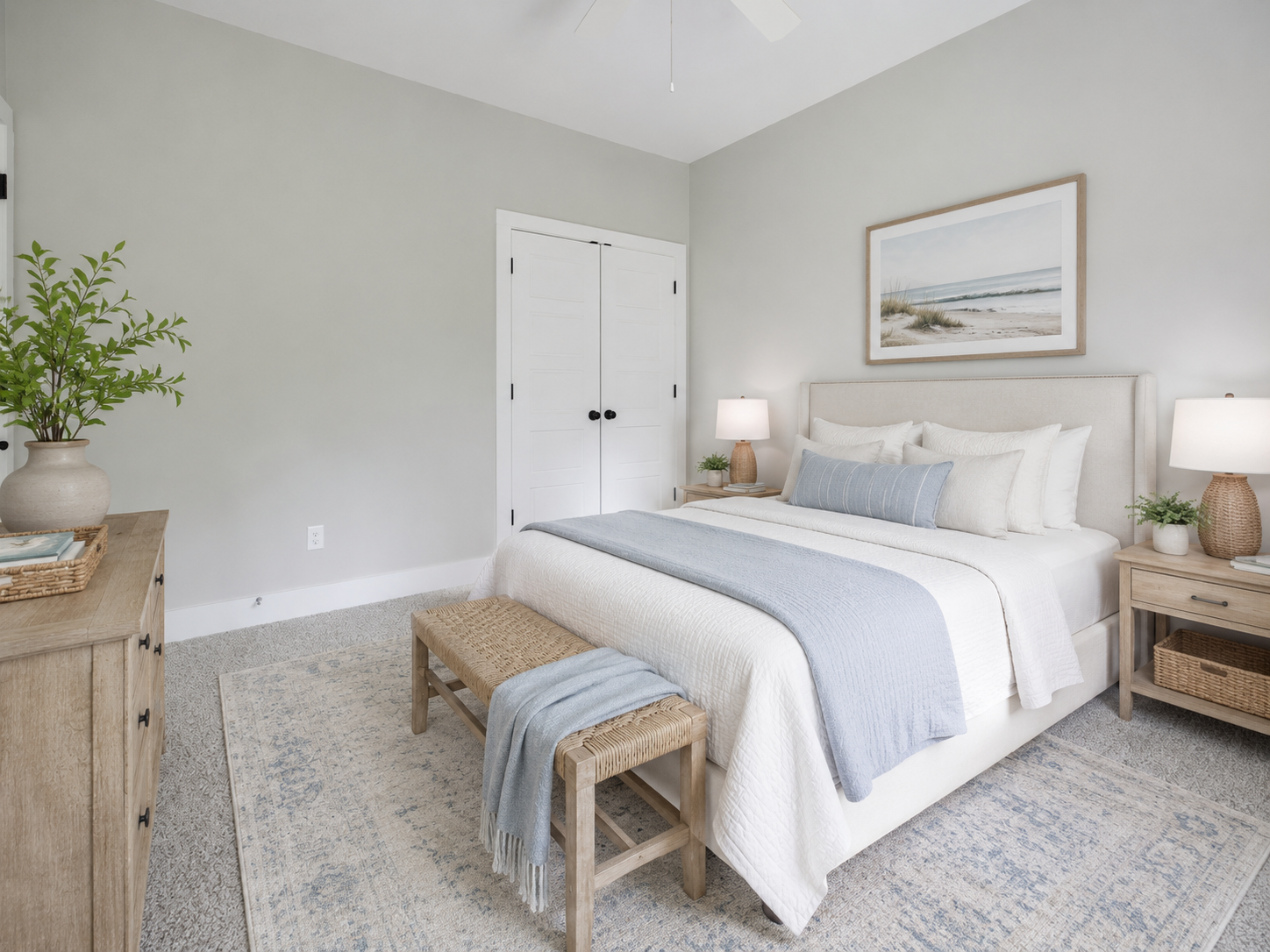 Secondary bedroom with soft blue accents, woven bench, and plush carpeting