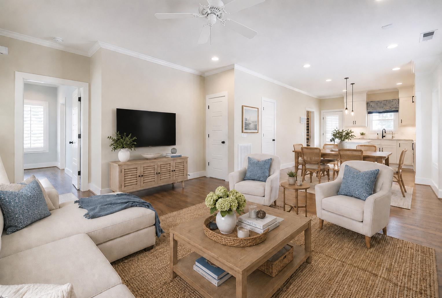 Living room with TV wall, seating area, and kitchen view